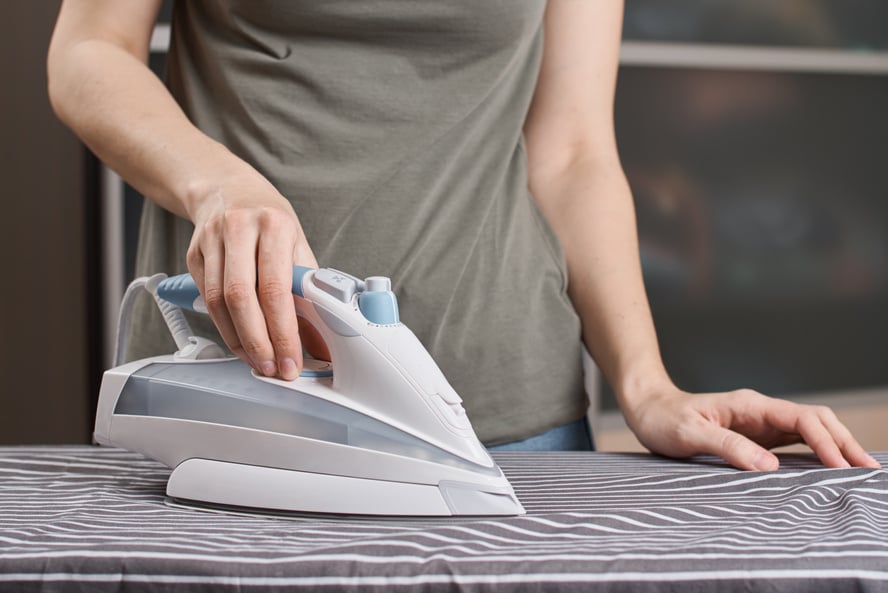 Woman Ironing Clothes on the Ironing Board with Modern Iron